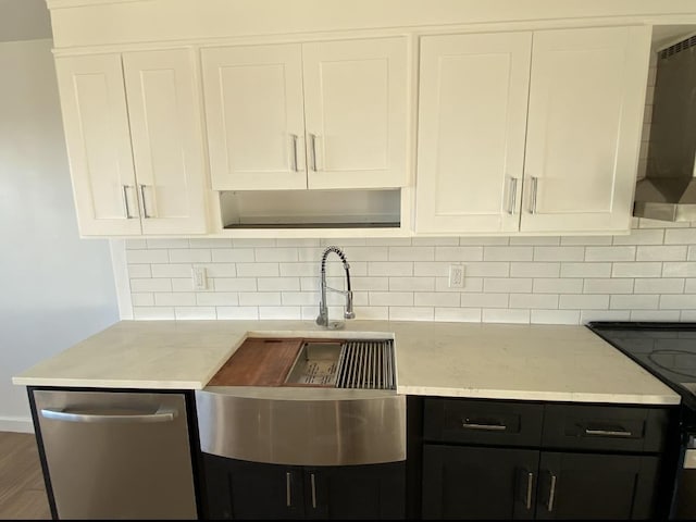 kitchen with dark cabinetry, range hood, white cabinetry, range, and tasteful backsplash