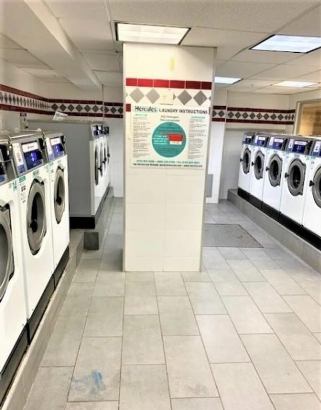 common laundry area featuring washer and dryer and light tile patterned floors