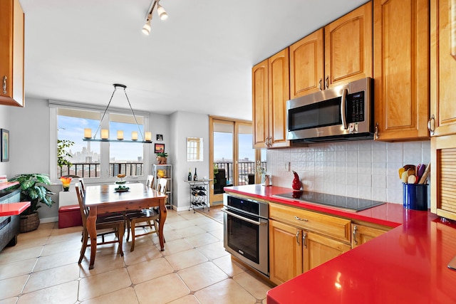 kitchen with tasteful backsplash, light tile patterned floors, hanging light fixtures, and appliances with stainless steel finishes