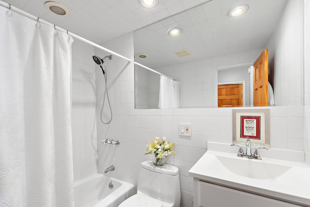 full bathroom with vanity, toilet, shower / bath combo with shower curtain, and tile walls