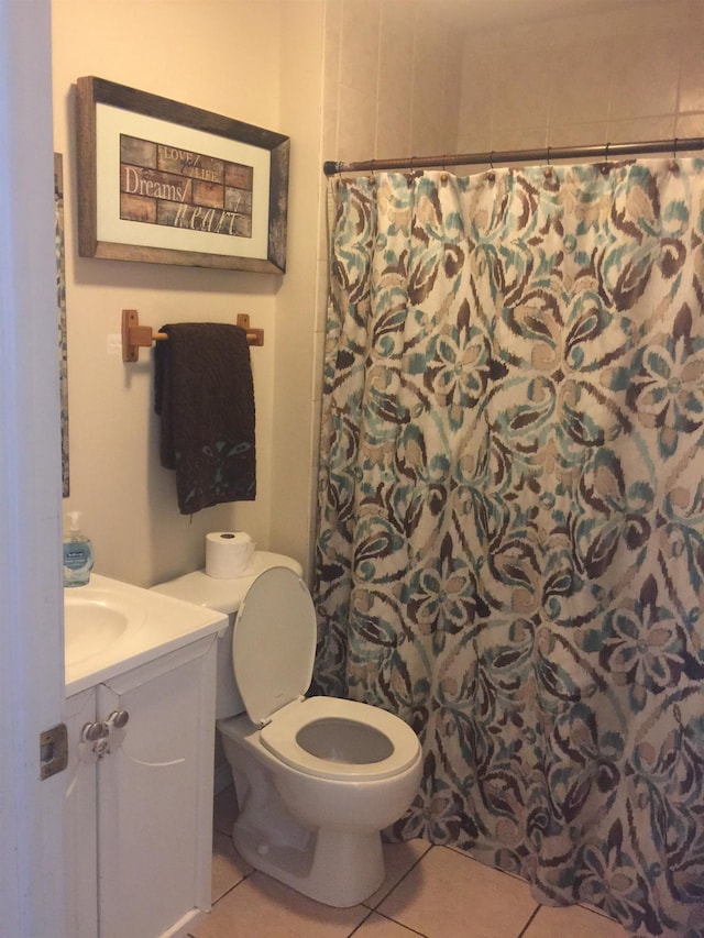 bathroom with tile patterned floors, vanity, walk in shower, and toilet