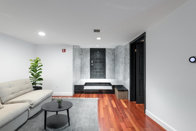 living room with recessed lighting, baseboards, visible vents, and wood finished floors
