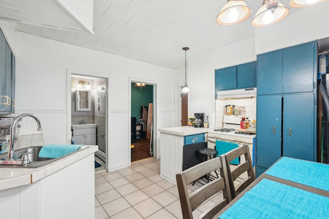 103 Kennedy Blvd, Bayonne, NJ 07002 - kitchen featuring under cabinet range hood, a sink, blue cabinets, white range with gas cooktop, and light tile patterned floors