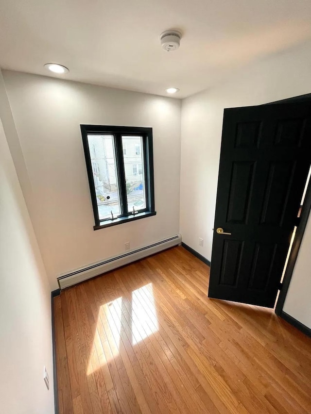 119 W 19th St, Bayonne, NJ 07002 - spare room featuring a baseboard radiator, a smoke detector, light wood-style flooring, and recessed lighting