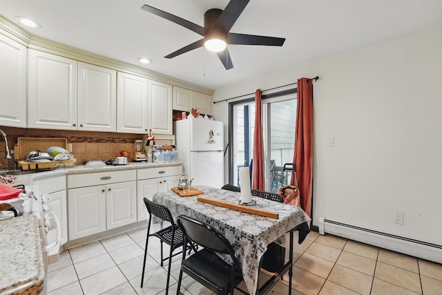 119 W 19th St, Bayonne, NJ 07002 - kitchen with freestanding refrigerator, baseboard heating, light tile patterned flooring, light countertops, and recessed lighting