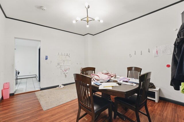 119 W 19th St, Bayonne, NJ 07002 - dining space featuring a chandelier, baseboard heating, and wood finished floors
