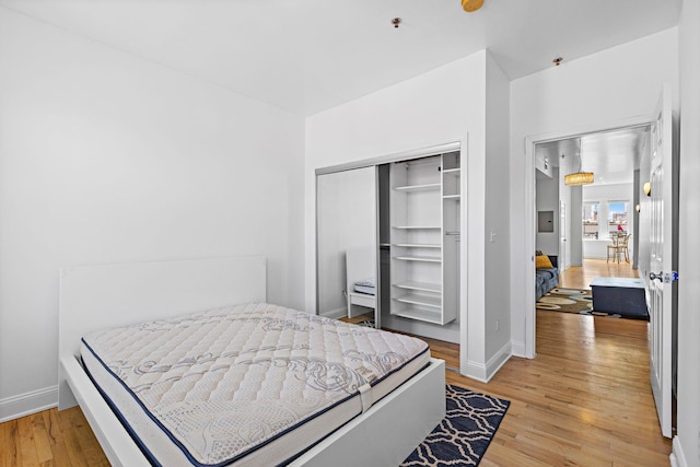 231 Grand St Unit 5R, Hoboken, NJ 07030 - bedroom featuring light wood-style flooring, baseboards, and a closet