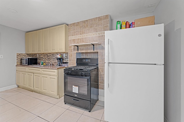 kitchen featuring sink, tasteful backsplash, black range with gas stovetop, white refrigerator, and light tile patterned floors