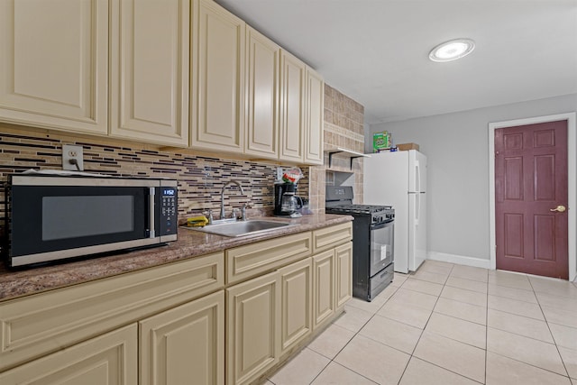 kitchen with sink, backsplash, cream cabinets, black gas stove, and light tile patterned floors