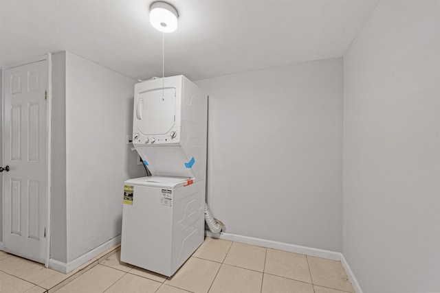 washroom with light tile patterned floors and stacked washer and dryer