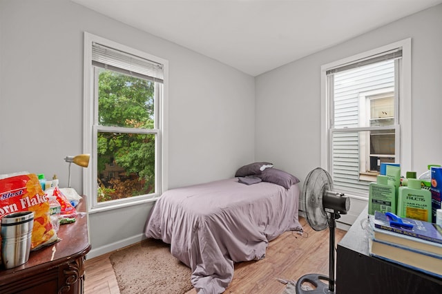 bedroom with multiple windows and light wood-type flooring