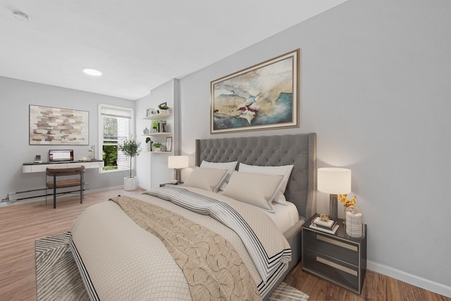 bedroom with hardwood / wood-style flooring and baseboard heating