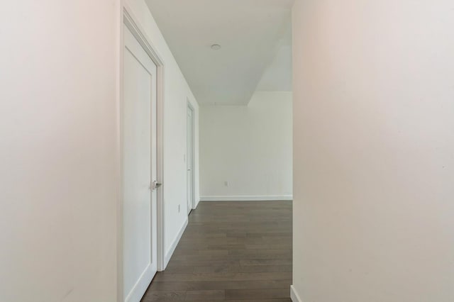 corridor featuring dark wood-style floors and baseboards