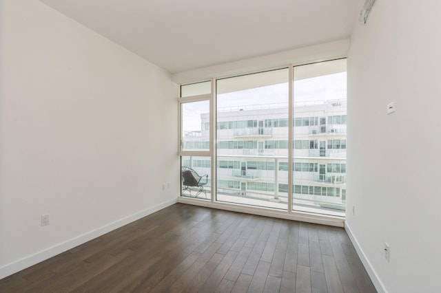 unfurnished room with dark wood-style floors and baseboards