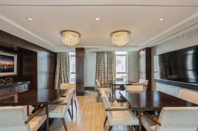 dining space with light wood-style floors, recessed lighting, and a notable chandelier