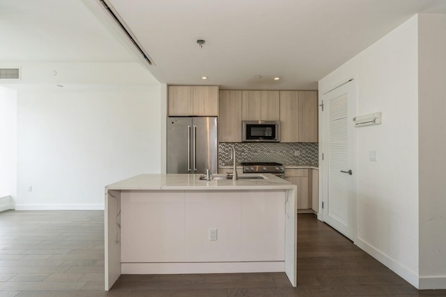 kitchen with stainless steel appliances, a sink, visible vents, light countertops, and decorative backsplash