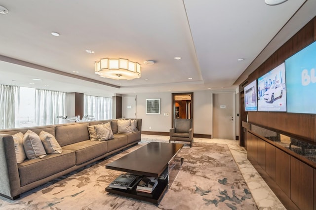 living room featuring a tray ceiling, marble finish floor, and recessed lighting