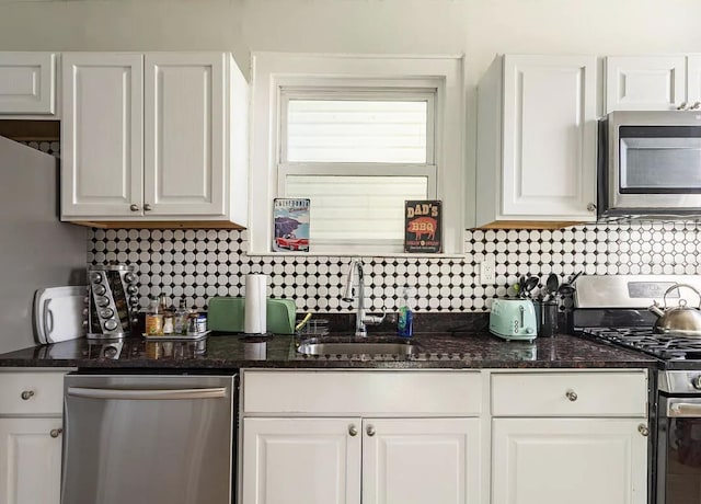 kitchen with stainless steel appliances, a sink, and white cabinets