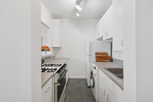 110 Morris St Unit 301, Jersey City, NJ 07302 - kitchen with white range with gas cooktop, washer and clothes dryer, dark stone finish floors, white cabinets, and light countertops