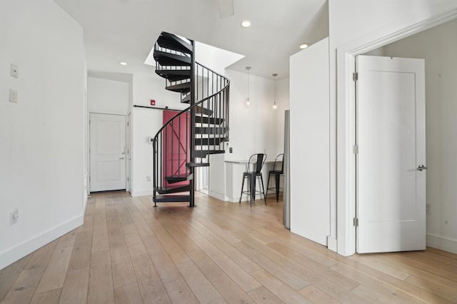 foyer entrance featuring light wood-type flooring, baseboards, stairway, and recessed lighting