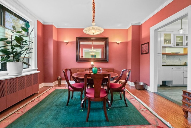 2600 Kennedy Blvd Unit 1H, Jersey City, NJ 07306 - dining space featuring wood finished floors, plenty of natural light, ornamental molding, and radiator heating unit