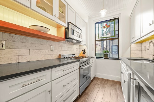 2600 Kennedy Blvd Unit 1H, Jersey City, NJ 07306 - kitchen featuring appliances with stainless steel finishes, healthy amount of natural light, white cabinetry, and dark countertops