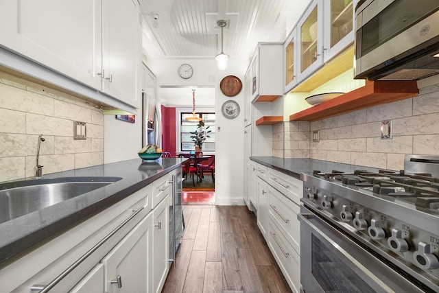 2600 Kennedy Blvd Unit 1H, Jersey City, NJ 07306 - kitchen featuring stainless steel appliances, decorative backsplash, white cabinetry, dark wood finished floors, and hanging light fixtures