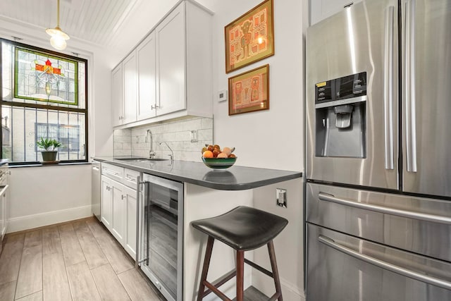 2600 Kennedy Blvd Unit 1H, Jersey City, NJ 07306 - kitchen with appliances with stainless steel finishes, beverage cooler, dark countertops, decorative backsplash, and white cabinets