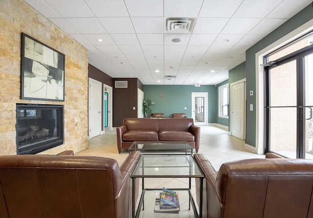 living room with visible vents, recessed lighting, a glass covered fireplace, and tile patterned floors