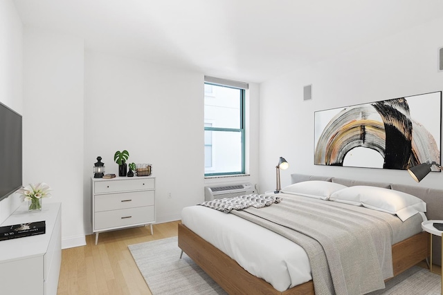 10 Regent St Unit 209X, Jersey City, NJ 07302 - bedroom featuring light wood finished floors, a wall mounted AC, and baseboards