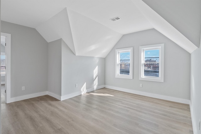 additional living space featuring light hardwood / wood-style floors and lofted ceiling