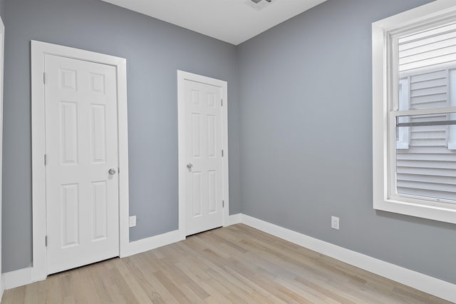 unfurnished bedroom with light wood-type flooring