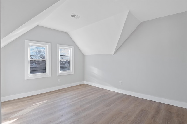 bonus room with light hardwood / wood-style flooring and vaulted ceiling