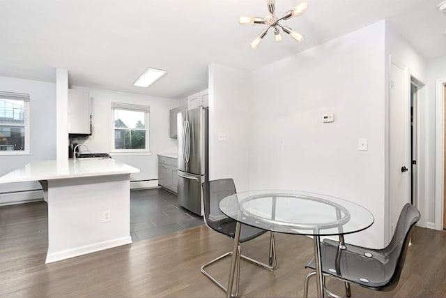 1 Congress St Unit 304, Jersey City, NJ 07307 - kitchen with freestanding refrigerator, a chandelier, baseboard heating, a peninsula, and light countertops
