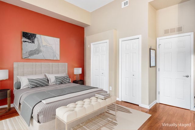 bedroom featuring wood finished floors, visible vents, and baseboards