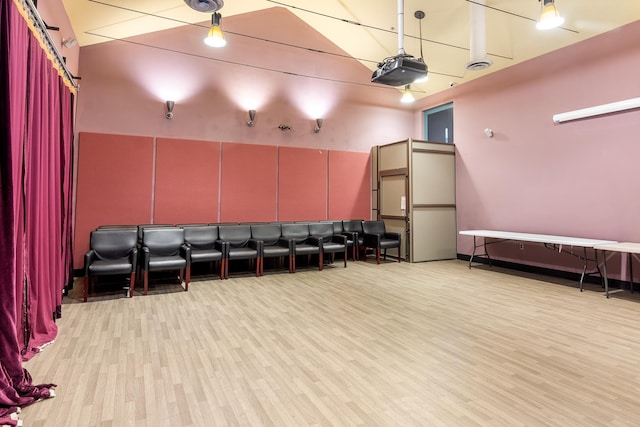 cinema room with a high ceiling and wood finished floors