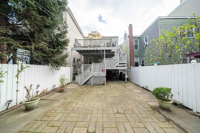rear view of property featuring a patio, a fenced backyard, and stairs