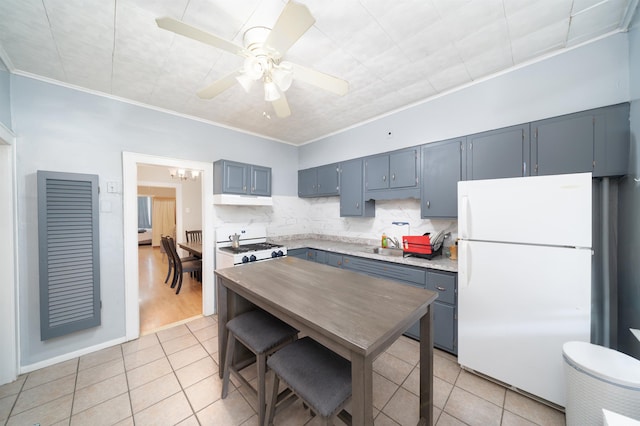 kitchen featuring crown molding, white appliances, light countertops, tasteful backsplash, and light tile patterned floors