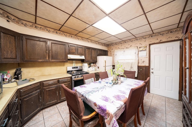 dining room with wallpapered walls and a paneled ceiling