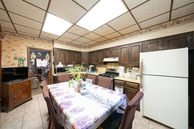 dining area with light tile patterned floors, wallpapered walls, and a paneled ceiling