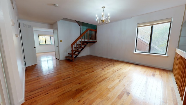 602 Sanderling Ct Unit 602, Secaucus, NJ 07094 - empty room with stairs, a notable chandelier, light wood-style flooring, and baseboards