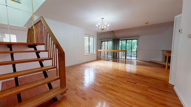602 Sanderling Ct Unit 602, Secaucus, NJ 07094 - unfurnished living room featuring baseboards, an inviting chandelier, plenty of natural light, and wood finished floors