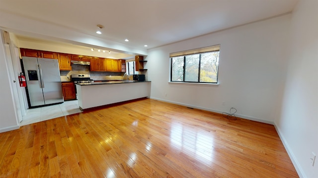 602 Sanderling Ct Unit 602, Secaucus, NJ 07094 - kitchen featuring under cabinet range hood, a peninsula, decorative backsplash, dark countertops, and stainless steel appliances