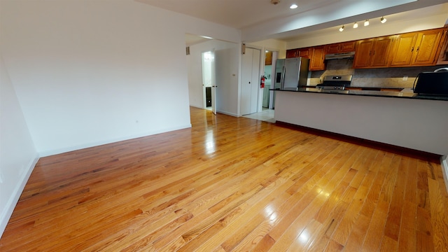 602 Sanderling Ct Unit 602, Secaucus, NJ 07094 - kitchen featuring under cabinet range hood, light wood finished floors, a peninsula, dark countertops, and stainless steel appliances