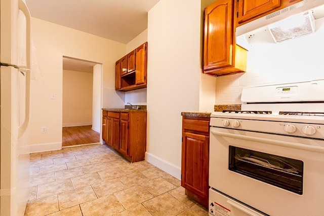 69 Belmont Ave, Jersey City, NJ 07304 - kitchen with white appliances, under cabinet range hood, and brown cabinetry