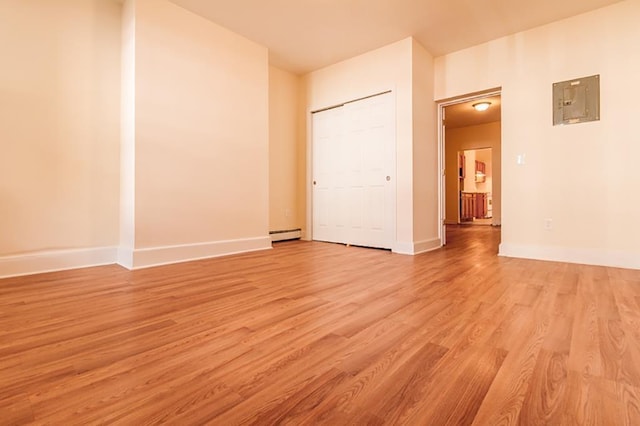 69 Belmont Ave, Jersey City, NJ 07304 - unfurnished bedroom featuring electric panel, light wood-type flooring, a baseboard heating unit, and baseboards