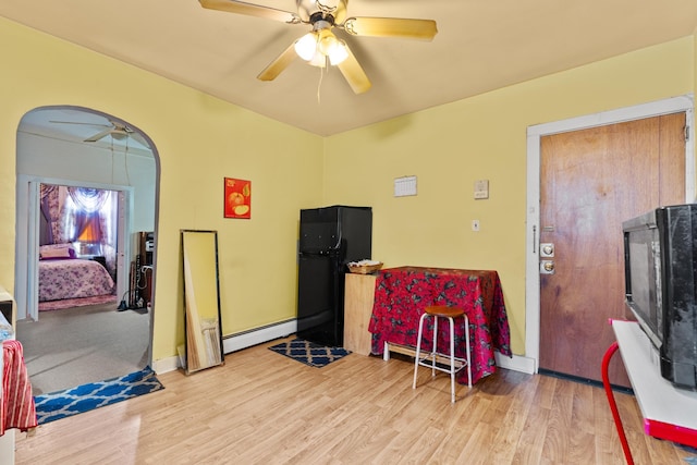 51 Lord Ave, Bayonne, NJ 07002 - living area featuring a baseboard heating unit, arched walkways, a ceiling fan, and wood finished floors