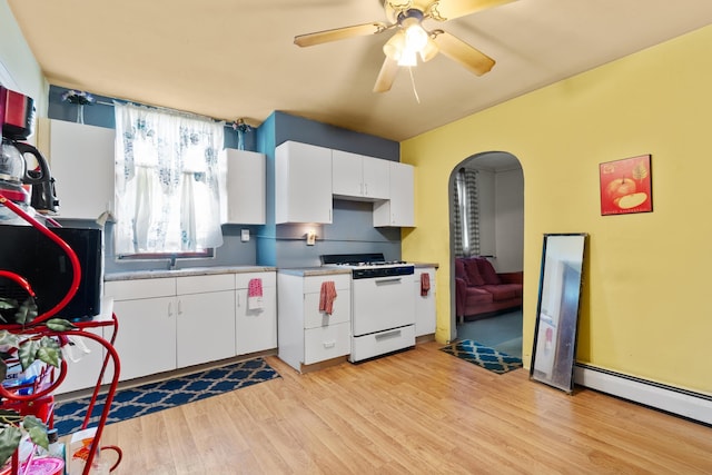 51 Lord Ave, Bayonne, NJ 07002 - kitchen with gas range gas stove, arched walkways, baseboard heating, light wood-style flooring, and white cabinetry
