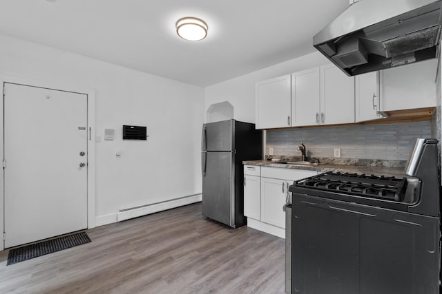 51 Lord Ave, Bayonne, NJ 07002 - kitchen with stainless steel appliances, a baseboard radiator, range hood, white cabinets, and decorative backsplash