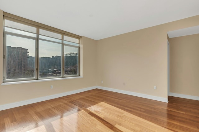 unfurnished room with hardwood / wood-style flooring